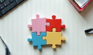Piezas de un rompecabezas encajando perfectamente sobre una mesa de oficina